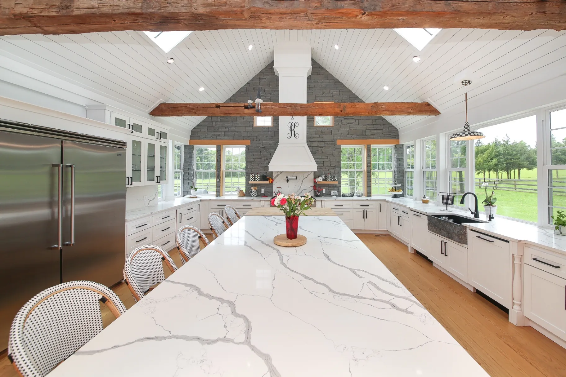Marble waterfall island and farmhouse sink in a luxury custom kitchen remodel